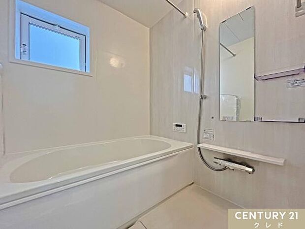 浴室乾燥機と浴室物干しが設置された充実設備の浴室です。ベンチタイプの浴槽はくつろぎの入浴を楽しめ、快適さと便利さを兼ね備えています。