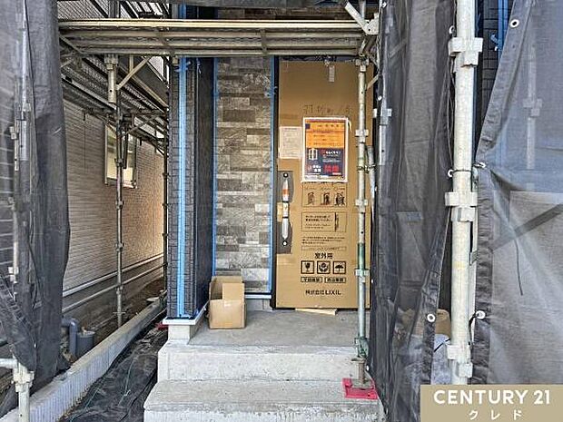 【1号棟】シートの中では外壁・室内工事が着々と進んでいきます。重厚感のある石目調サイディングが施工され、建物の表情が見えてきました。