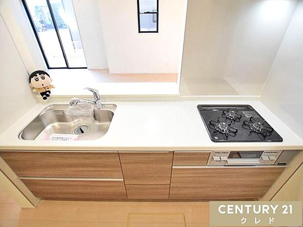 3口コンロと広々シンクを備えた対面式のシステムキッチン。リビングで遊ぶお子さまを見守りながら調理ができるので、毎日の家事も安心ですね。