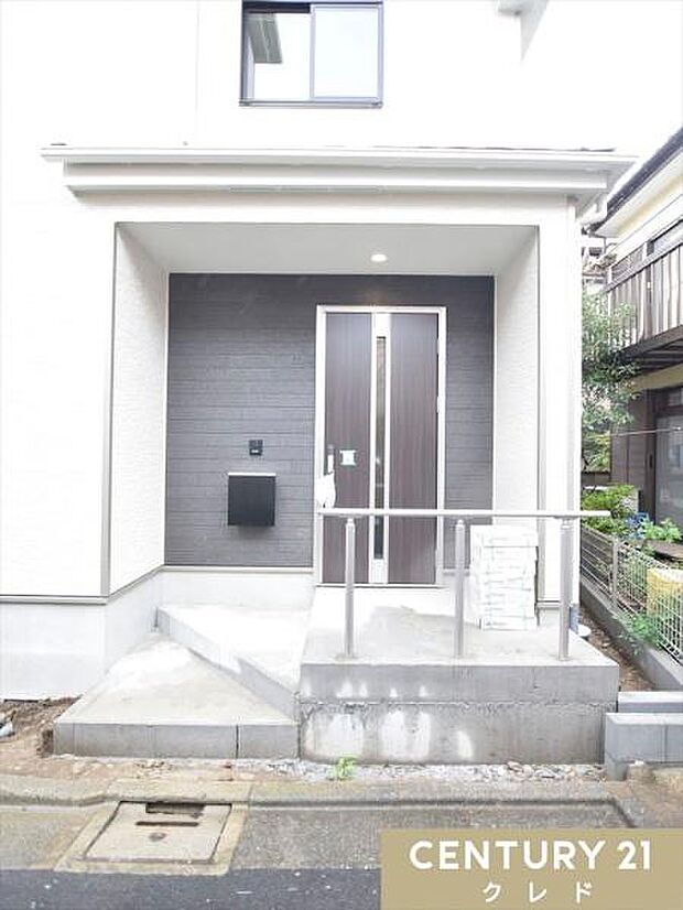 住まいの顔となる玄関は、白とグレーでまとめた上品なデザイン。手すり付きのアプローチが、日々の暮らしにさりげない安心感をプラスします。