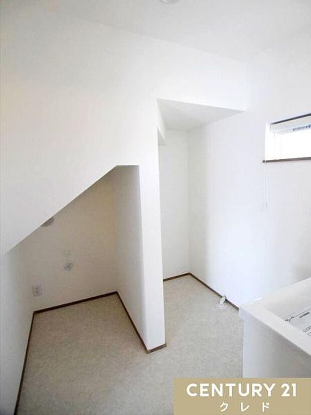 白を基調とした清潔感あふれる洗面室。階段下のスペースを有効活用し、洗濯機置き場をスッキリ配置しました。小窓付きで換気も良好です。