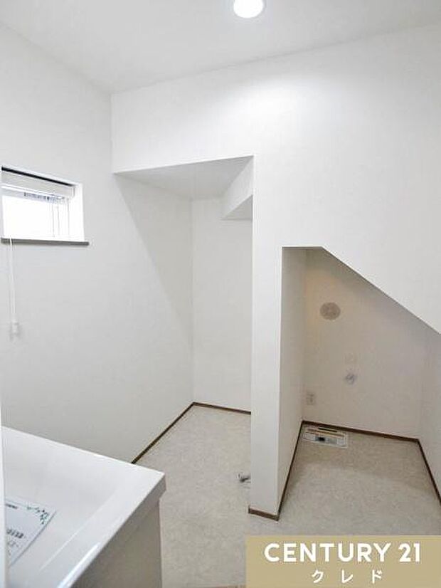 白を基調とした清潔感あふれる洗面室。階段下のスペースを有効活用し、洗濯機置き場をスッキリ配置しました。小窓付きで換気も良好です。