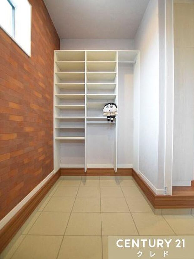 【シューズインクローク】壁一面の収納棚でご家族全員の靴をたっぷり収納できます。傘やコートを掛けられるスペースもあり、お出かけの準備もスムーズ。小窓付きで換気もバッチリです。