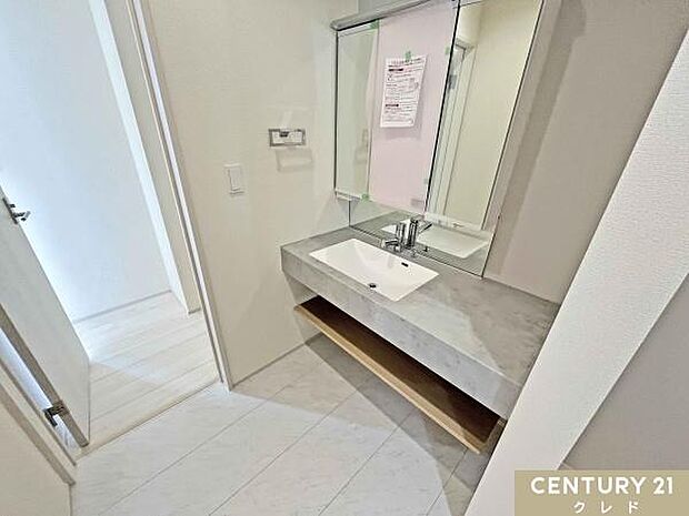 大理石調カウンターが映えるオープンサニタリー。広々とした洗面スペースと大型ミラーを採用し、ホテルライクな高級感を演出します。