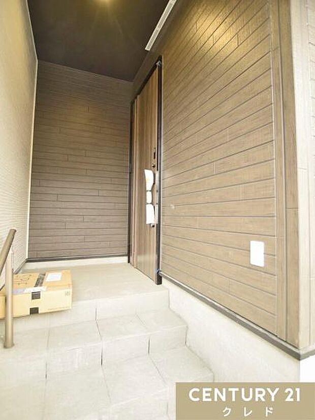 ゆとりある玄関ポーチは、雨の日でも慌てずに出入りしやすい設計。木目の温もりとブラックのアクセントが調和し、洗練された外観デザインが住まいの魅力を引き立てます。