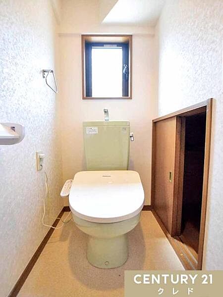 窓から自然光が入り、明るく爽やかな印象のトイレです。温水洗浄便座付きで毎日快適。引き戸付きの収納スペースがあり、ペーパーや掃除用品もスッキリ収納できます。