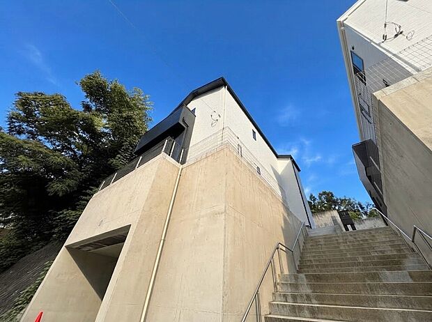 建物外観と階段、周囲に樹木が見える