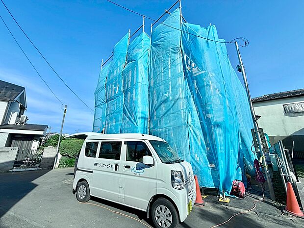 工事中の建物と駐車中の軽自動車が写っています
