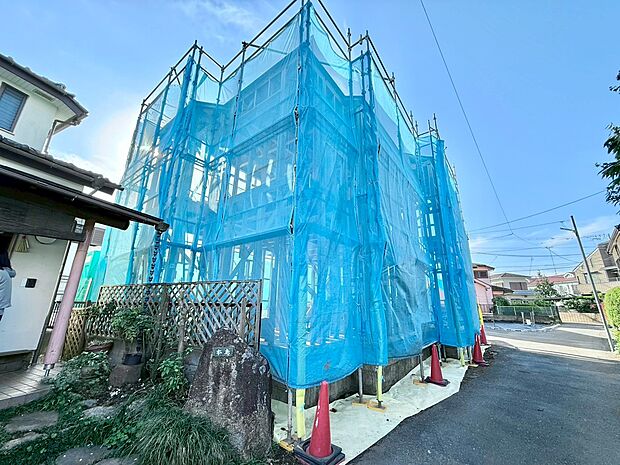 工事中の住宅外観青い養生ネットで覆われています