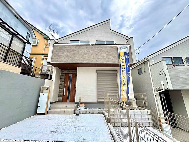 白い外壁の2階建て住宅と前面道路