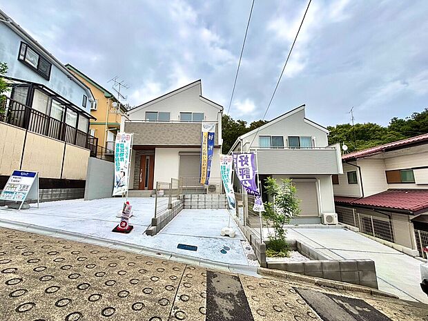 白い外壁の戸建て住宅と前面道路