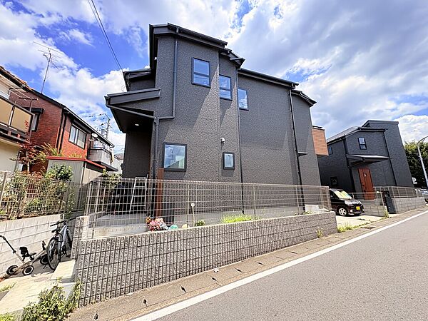住宅街にある2階建ての黒い外観の家です