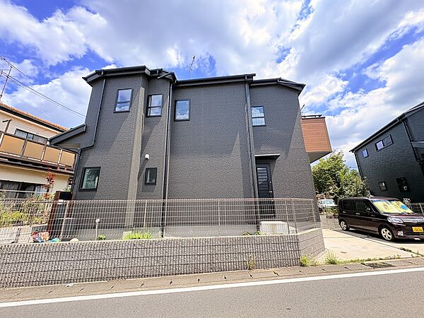 二階建ての黒い外観の住宅、閑静な住宅街に立地