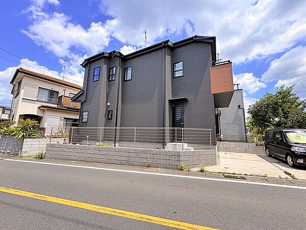 青空の下、道路に面した二階建て住宅の外観です