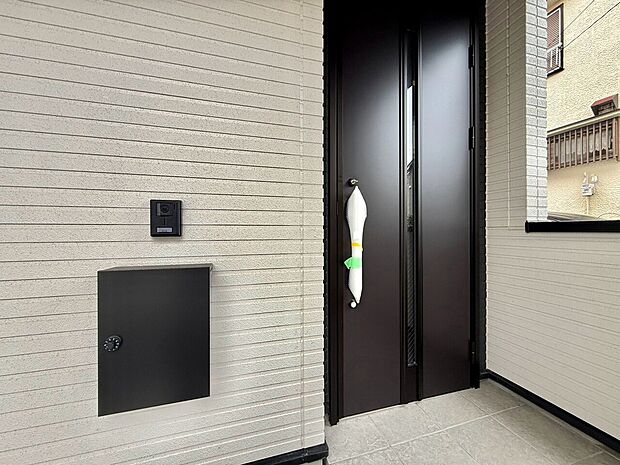 黒い玄関ドアと宅配ボックスのある玄関まわり