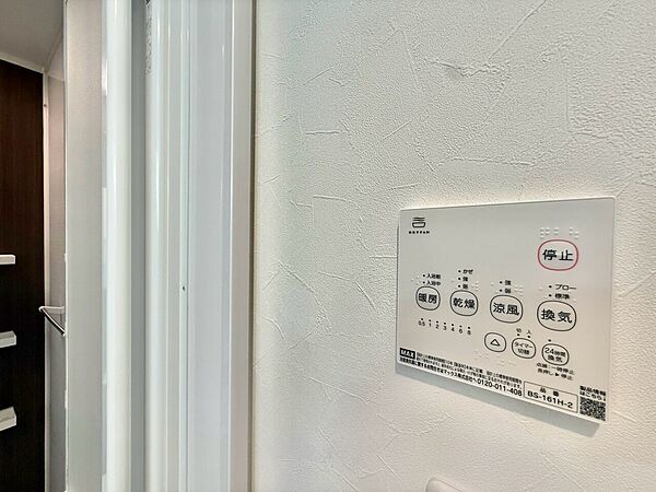 壁に設置された多機能リモコンの操作パネルです