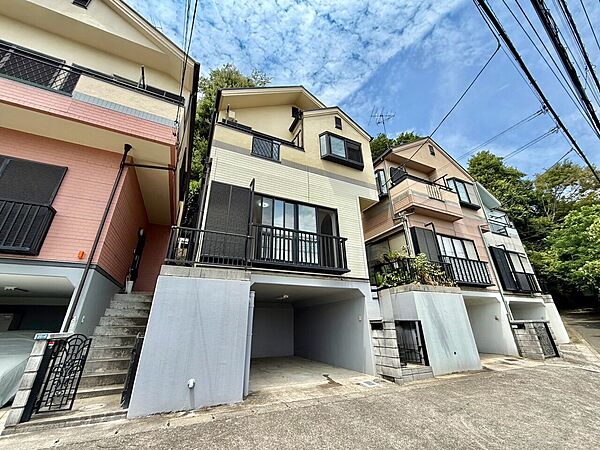 坂道に建つ3階建ての住宅外観駐車スペースあり
