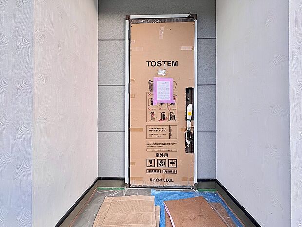 玄関ドア設置中の様子が見られる玄関スペース