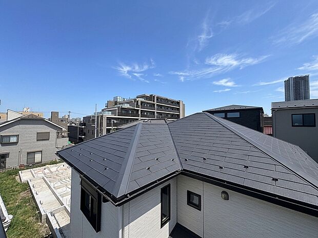 屋根越しに周辺の住宅や建物を望む眺め
