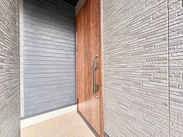 木製ドアとシャッターのある住宅の玄関部分です