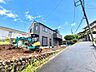 駐車場：建物と前面道路、整備中の敷地が見える外観