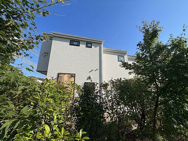 植栽に囲まれた住宅の外観
