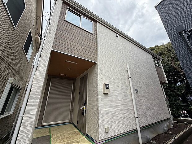 白い外壁の2階建て住宅の玄関まわり