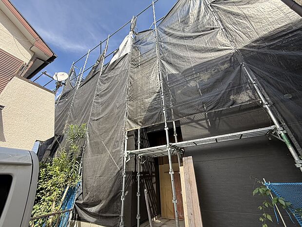 建物外観の一部足場と養生シートが設置されている