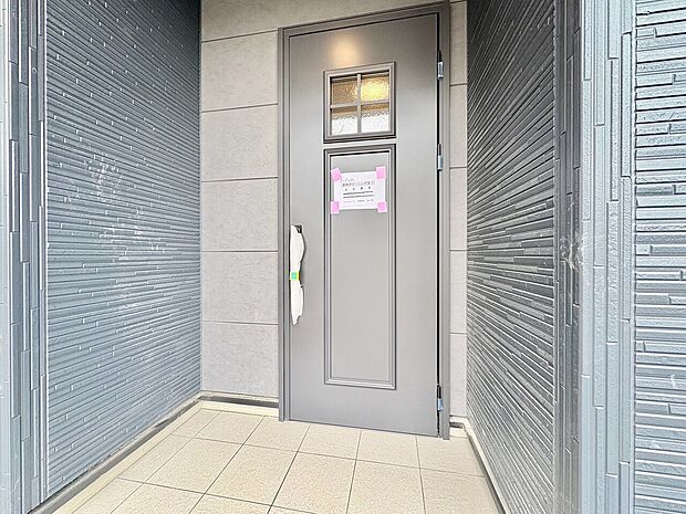 玄関ドアとタイル張りの玄関ポーチ
