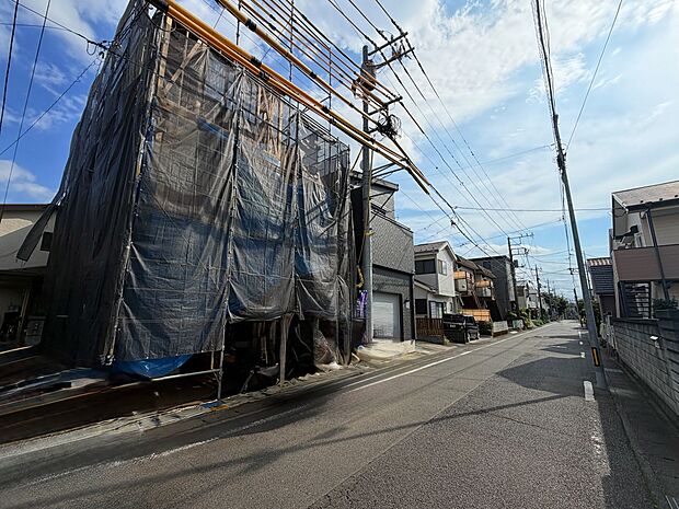 建築中の物件が並ぶ住宅街の道路沿いの様子です
