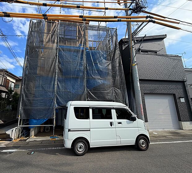 建設中の建物外観と手前の軽自動車