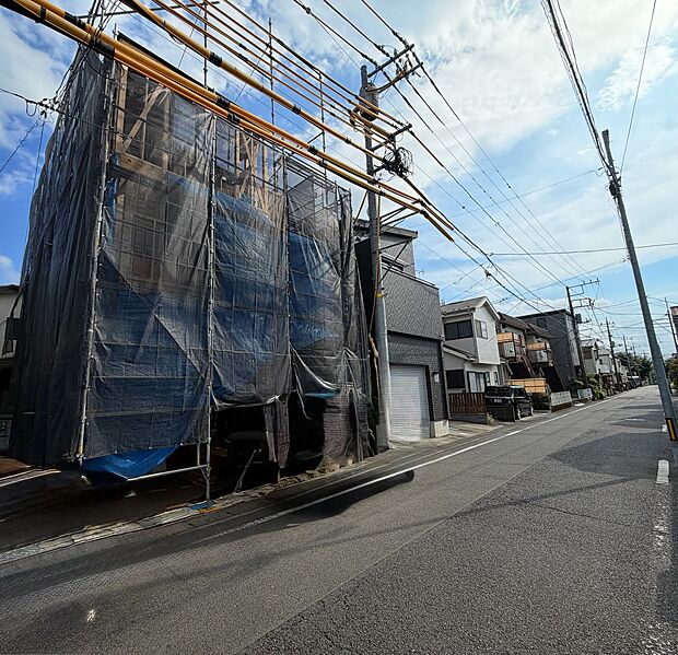 建設中の建物の外観と整備された周辺道路が見えます