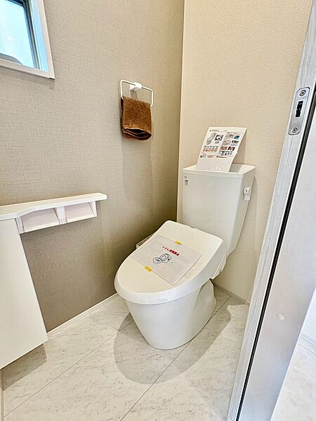 清潔感のあるトイレ空間で棚付きの収納も完備