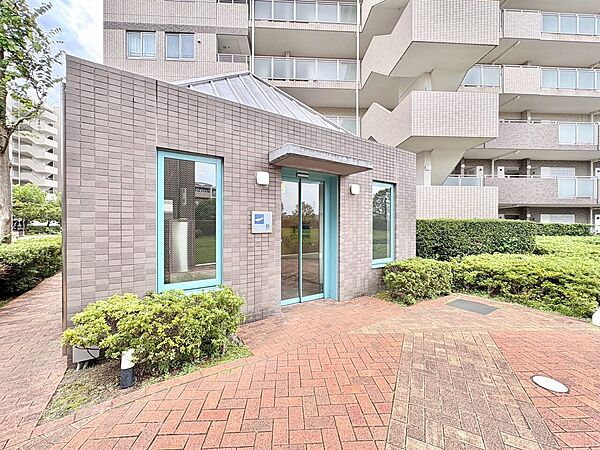 レンガ敷きの歩道と緑がある集合住宅の共用部です