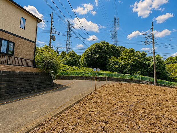 住宅近くの見晴らしの良い道路と畑の風景