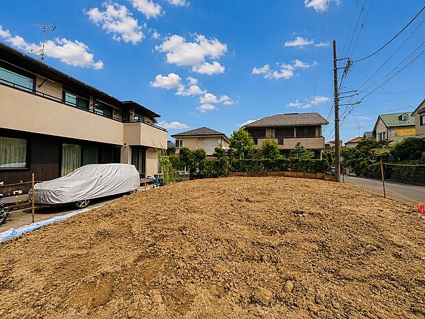 住宅地の整地済みの更地と周囲の住宅風景