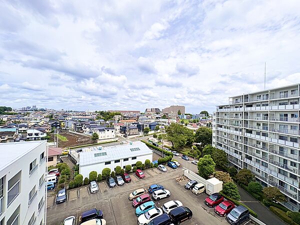 マンション敷地内の駐車場と周囲の住宅街の眺望