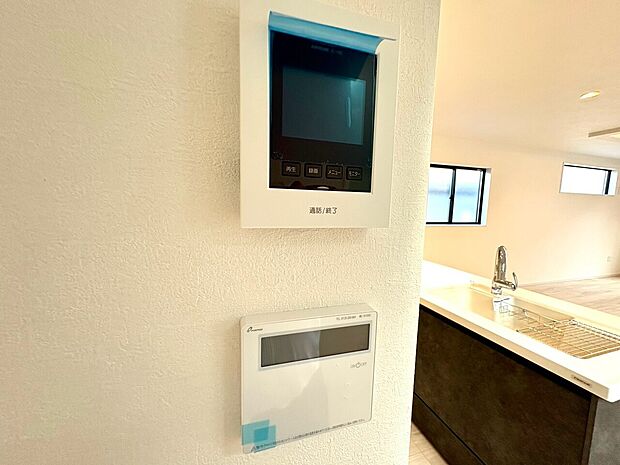 室内の壁に設置されたインターホンと空調操作パネル