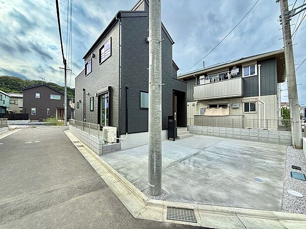 道路沿いに建つ住宅外観と敷地内の駐車スペース