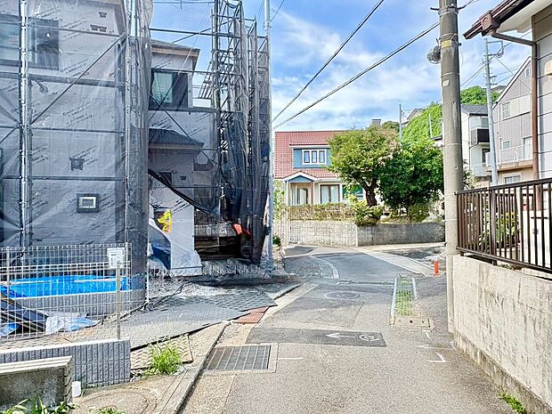 静かな住宅街の道路沿いに立つ物件の周辺環境