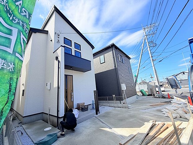 白い外壁の戸建て住宅と前面道路