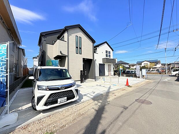 住宅外観と前面道路、駐車スペースの様子