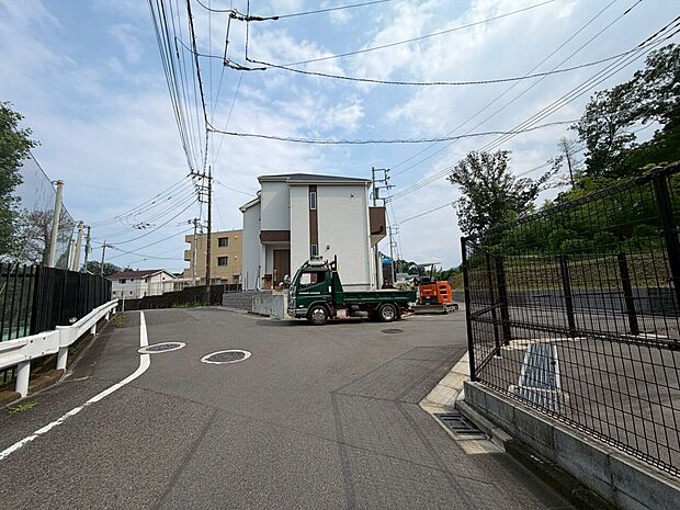 緑豊かな環境にある建物の外観と近隣道路の様子