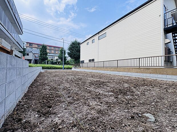 建物に囲まれた更地の売土地の様子