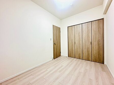 木目調の扉とフローリングの洋室