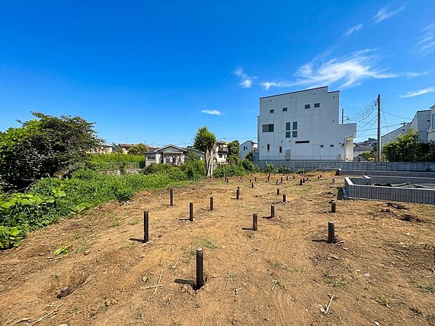 住宅街にある宅地の更地、周囲に建物が立ち並ぶ