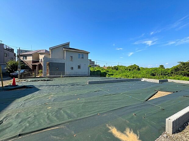 住宅地の広い更地と晴れた空の景観