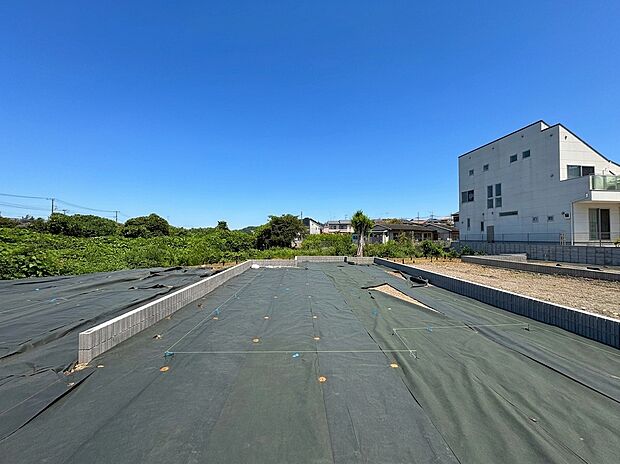 建物横の広い空き地と周囲の住宅環境
