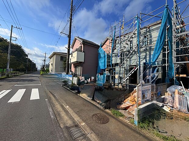 建築中の住宅が並ぶ住宅地の道路沿いの様子です