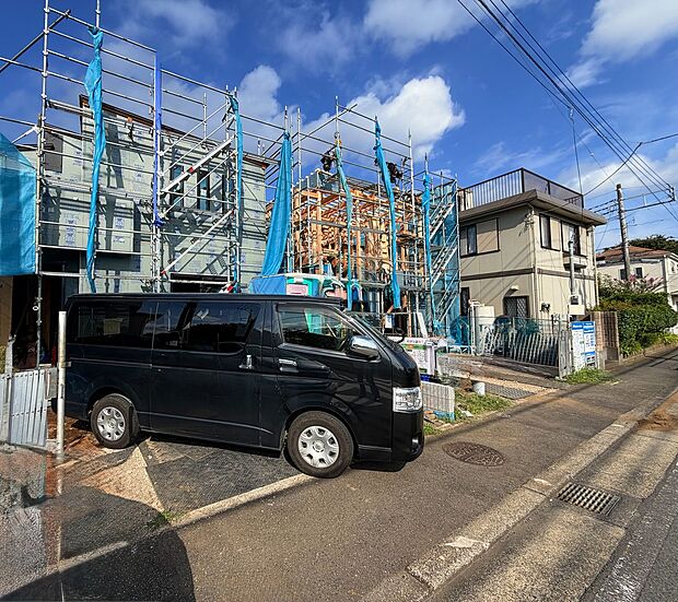 建設中の住宅と駐車場がある街並みの外観